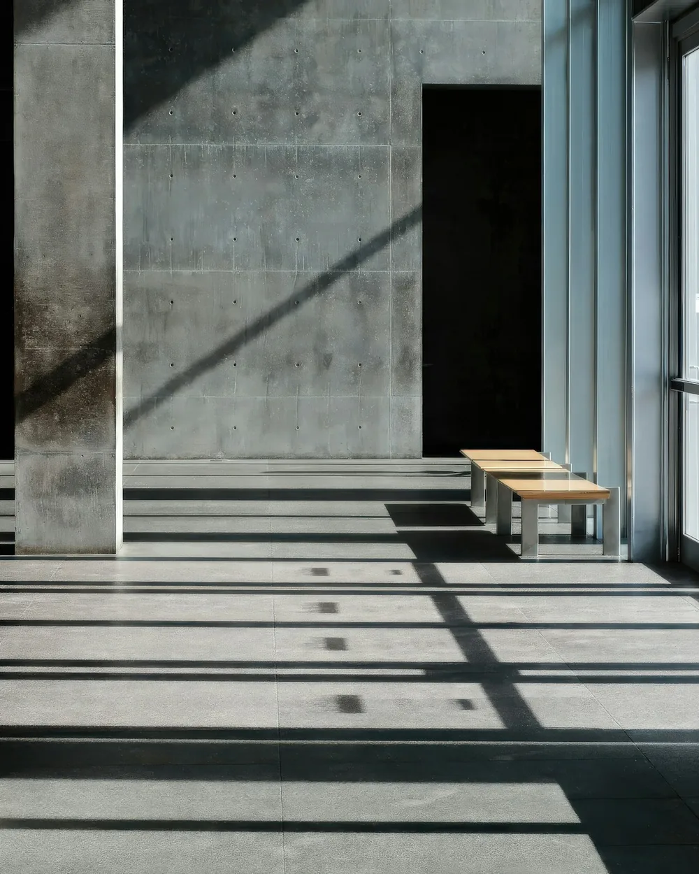 Concrete hallway with benches and long shafts of afternoon light