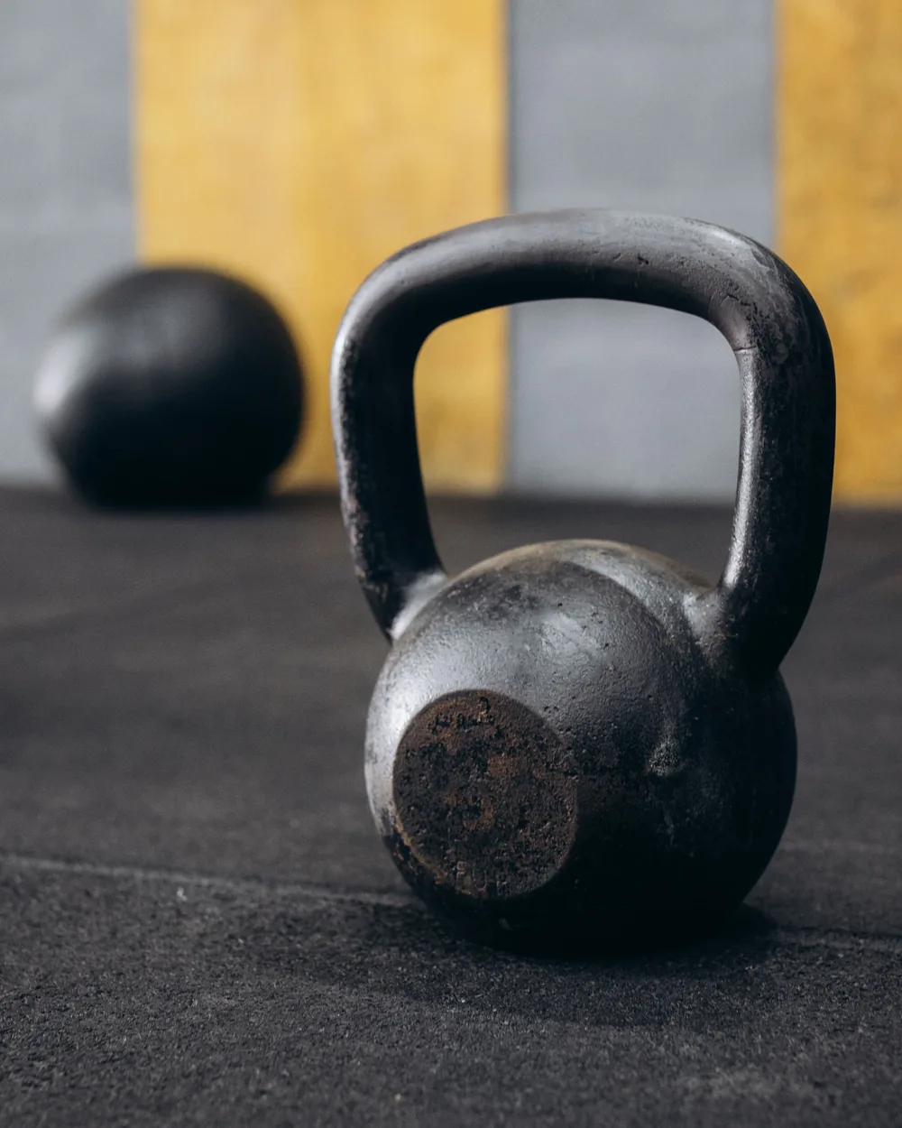 Cast iron kettlebell on a dark rubber gym floor